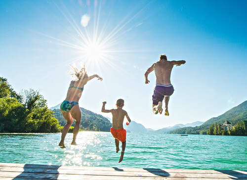 Eine Familie springt im Aktivurlaub im Salzkammergut  in den See