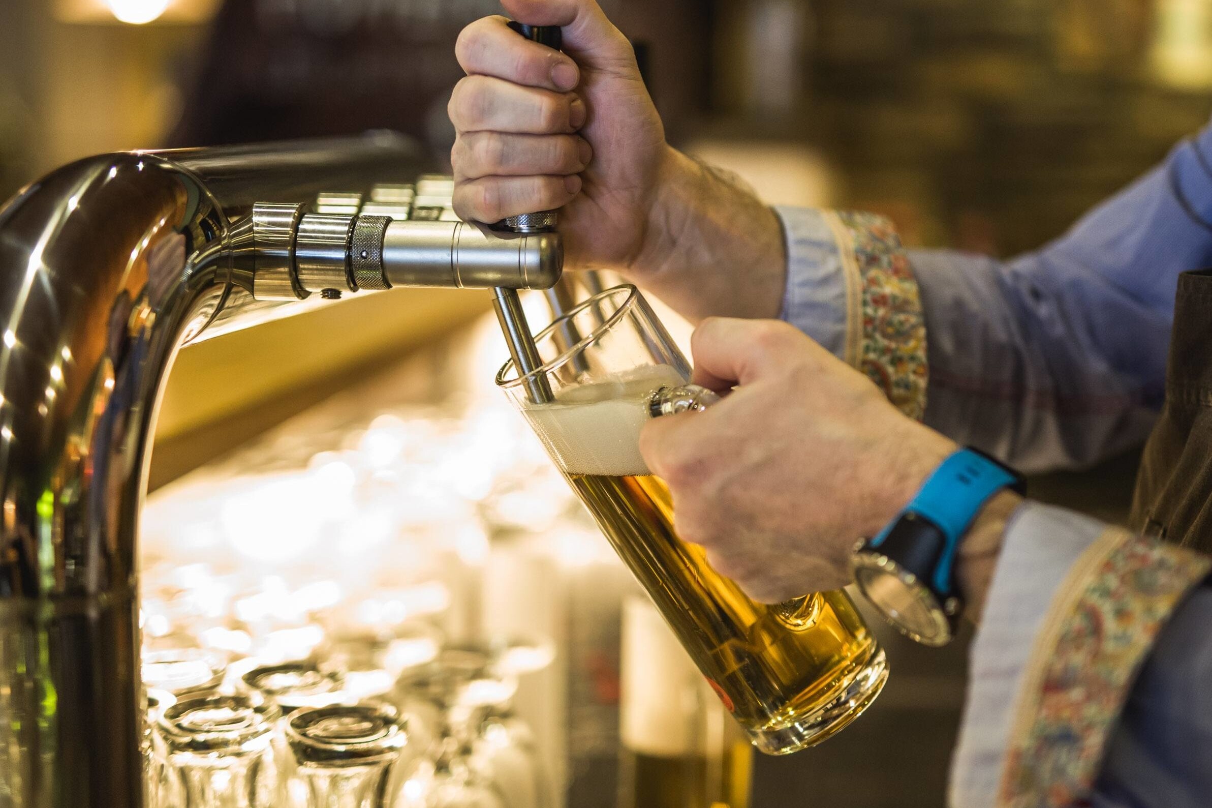 Detailansicht von einem Mann, der ein Bier im Gasthaus Obermayr zapft