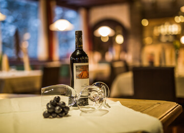 Detailansicht einer Flasche Wein mit Gläsern im Gasthaus Obermayr